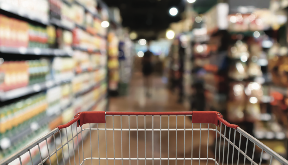 photo of shopping cart in an aisle at a grocery store